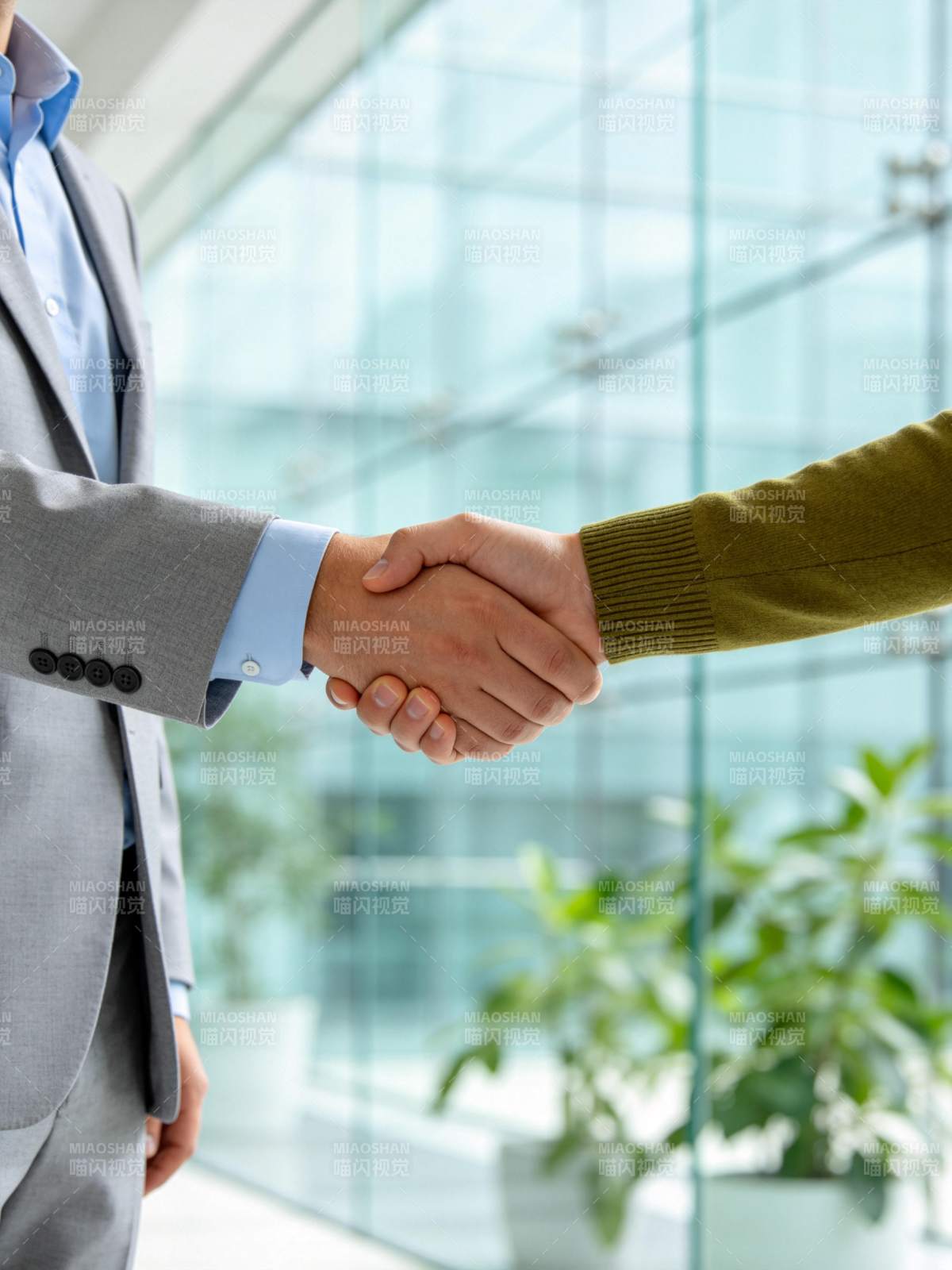 商务人士在现代办公室握手达成合作图片