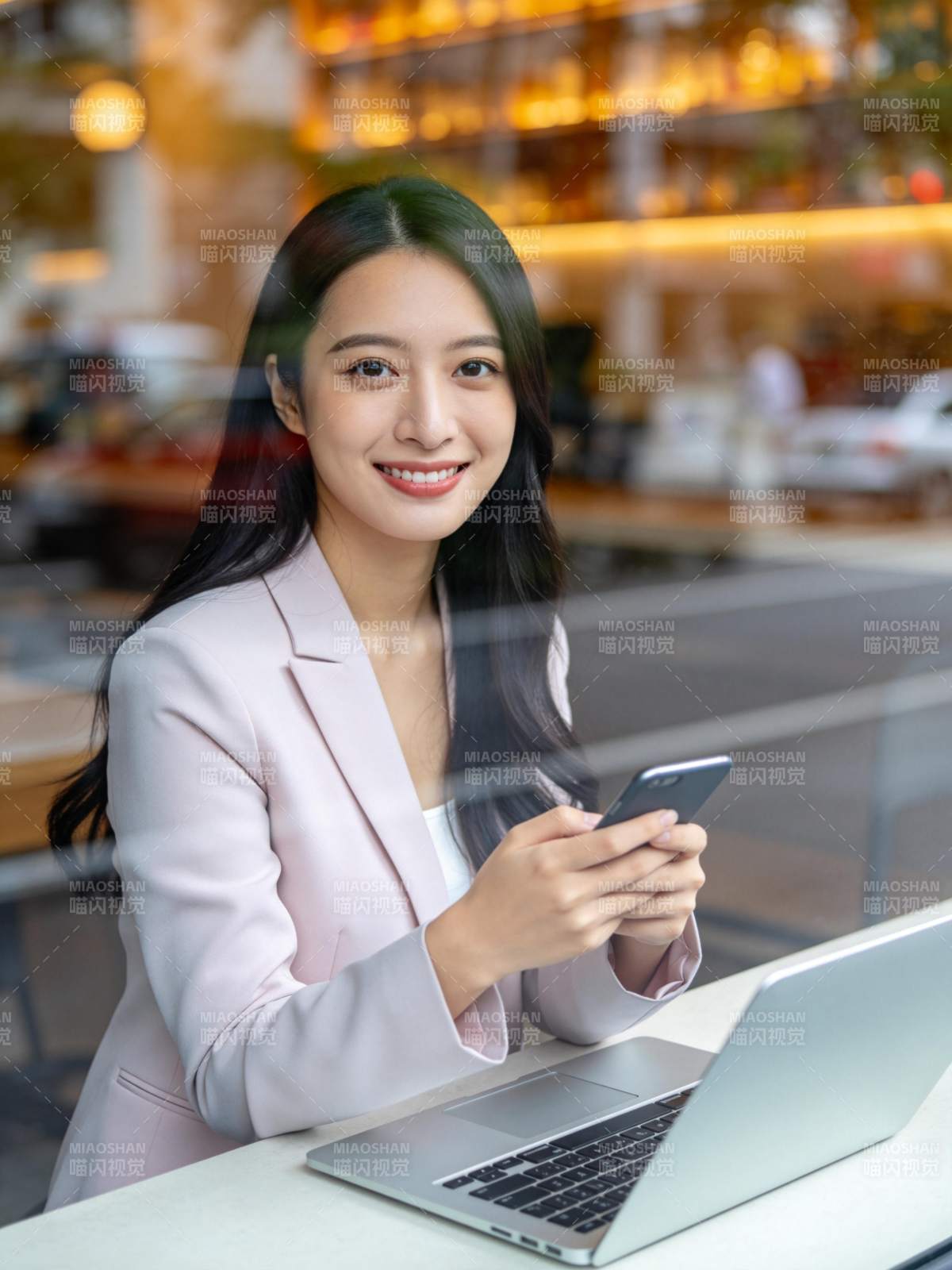 职场女性在咖啡馆使用手机与笔记本电脑工作图片