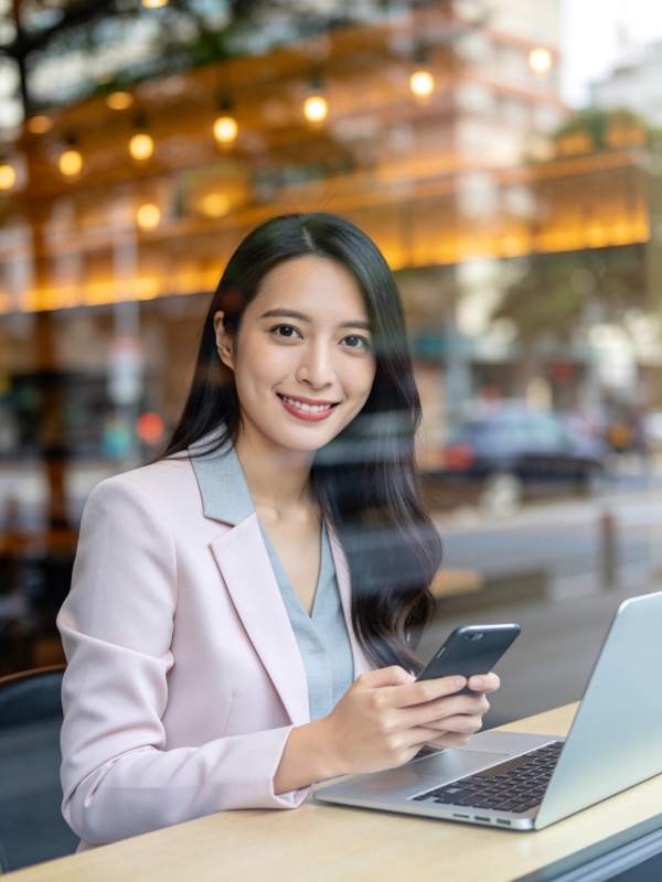 职场女性在咖啡馆使用手机与笔记本电脑工作图片