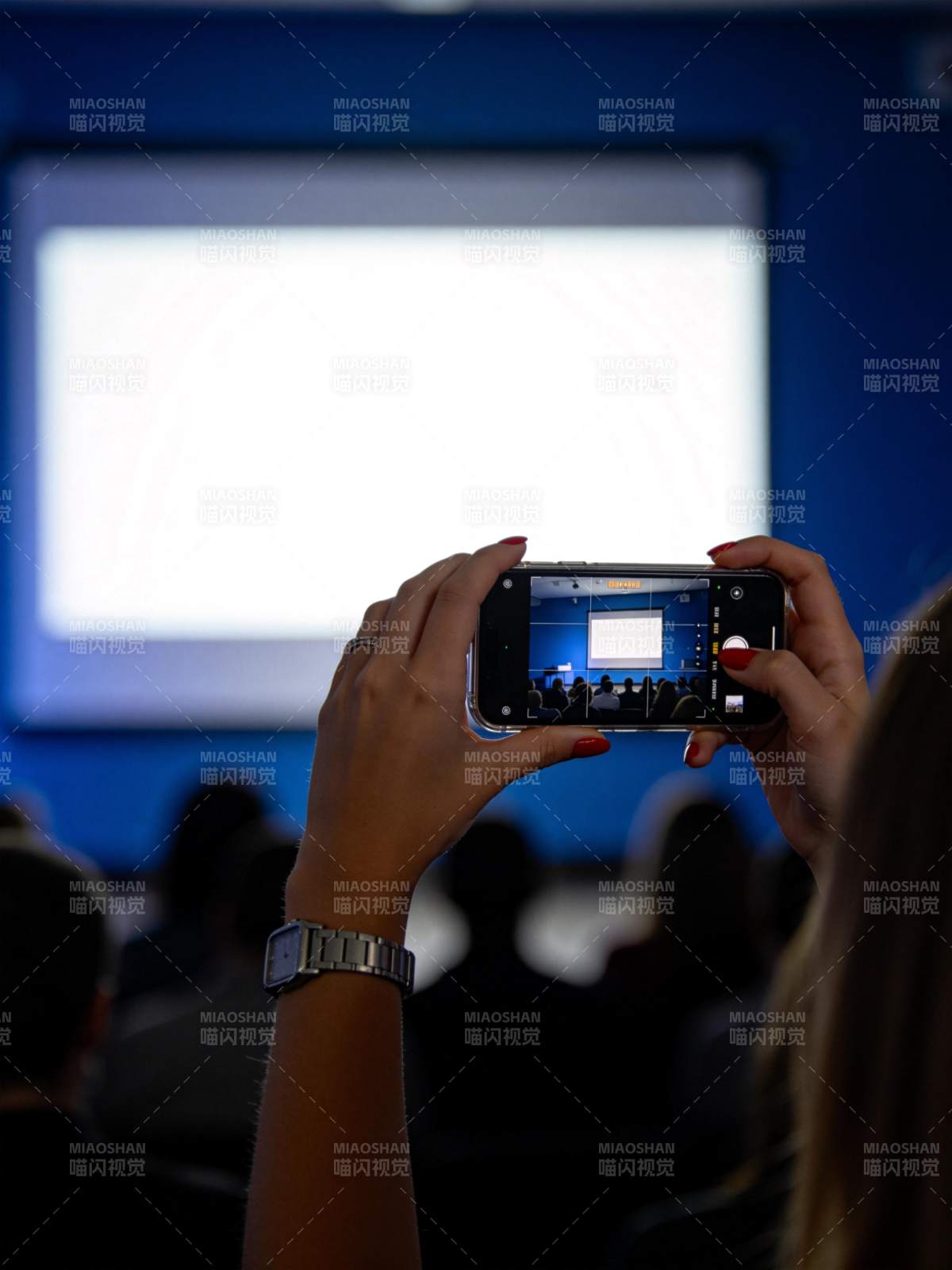 观众用手机拍摄投影屏幕上的演示内容图片