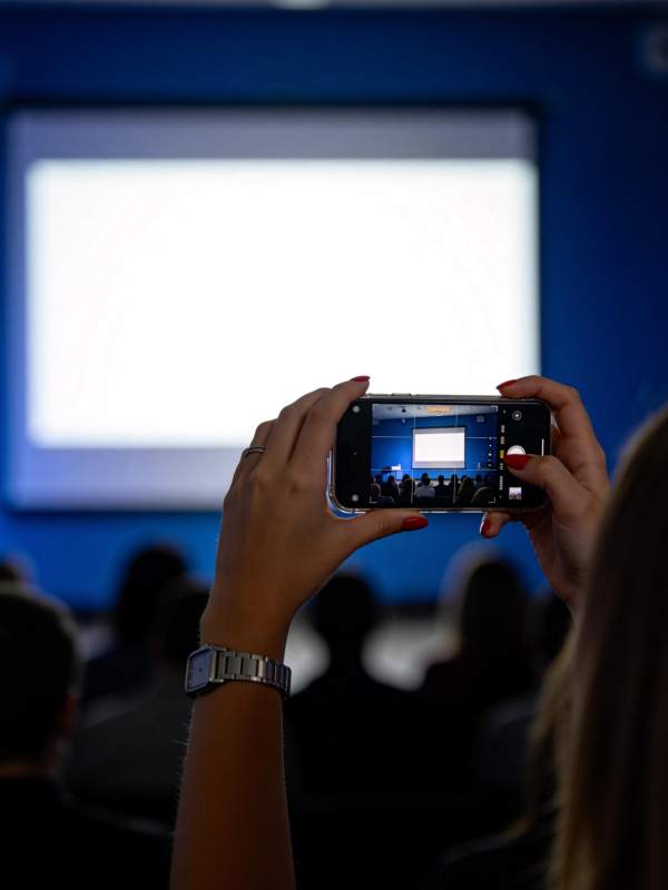 观众用手机拍摄投影屏幕上的演示内容图片