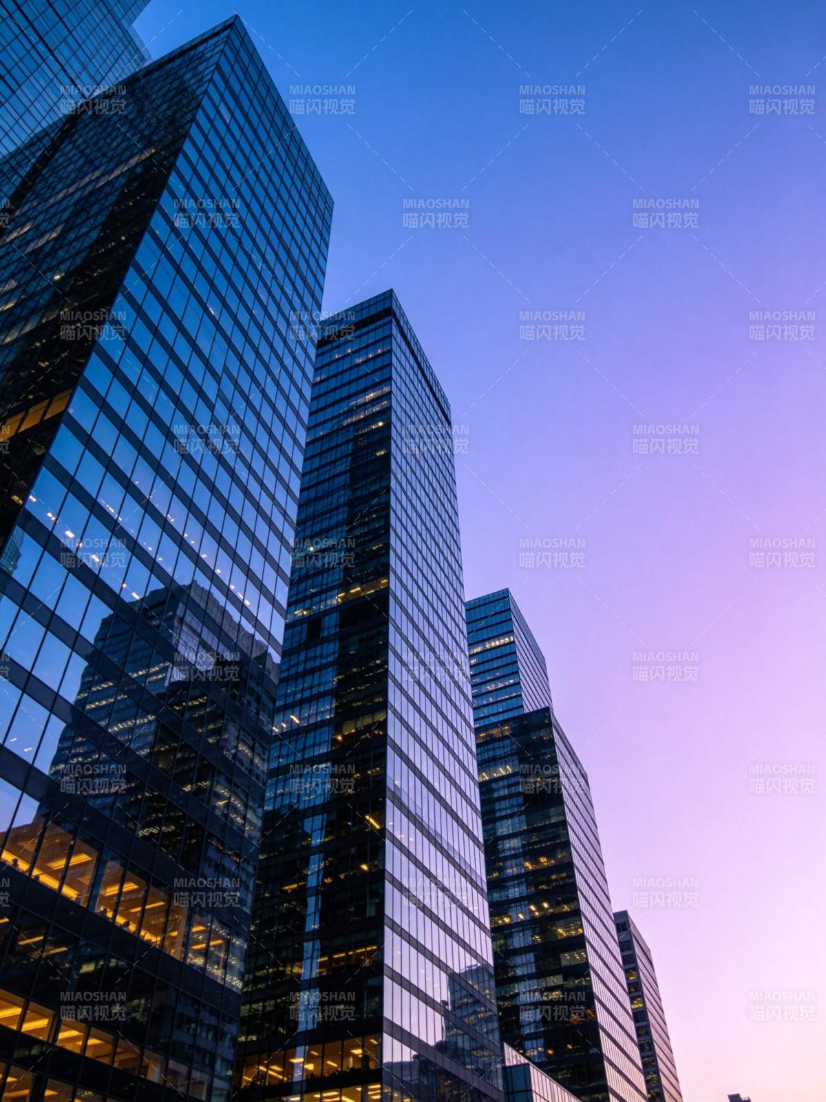 黄昏时分玻璃幕墙摩天大楼群仰拍景象图片