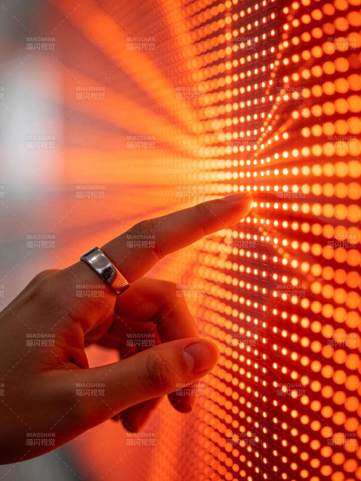 手指触碰发光点阵屏幕的特写画面图片