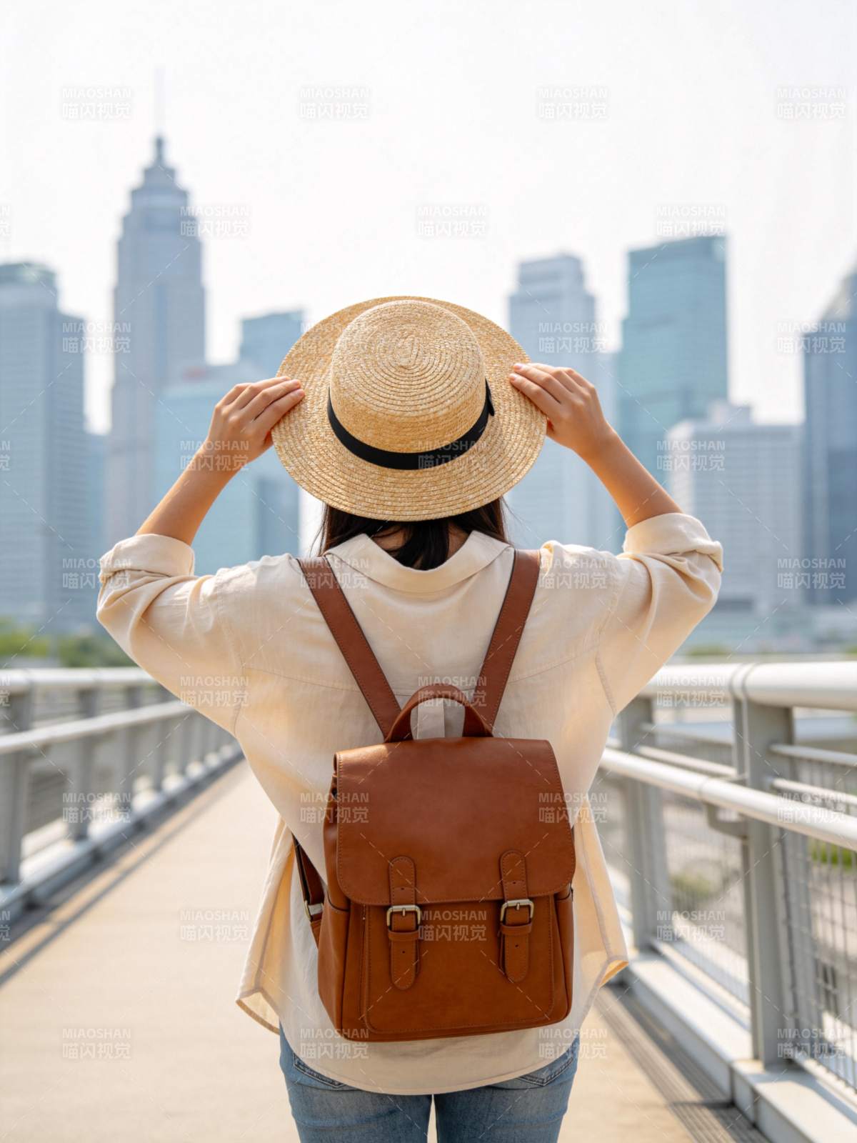 戴草帽背背包的女子站在城市天桥上远望图片