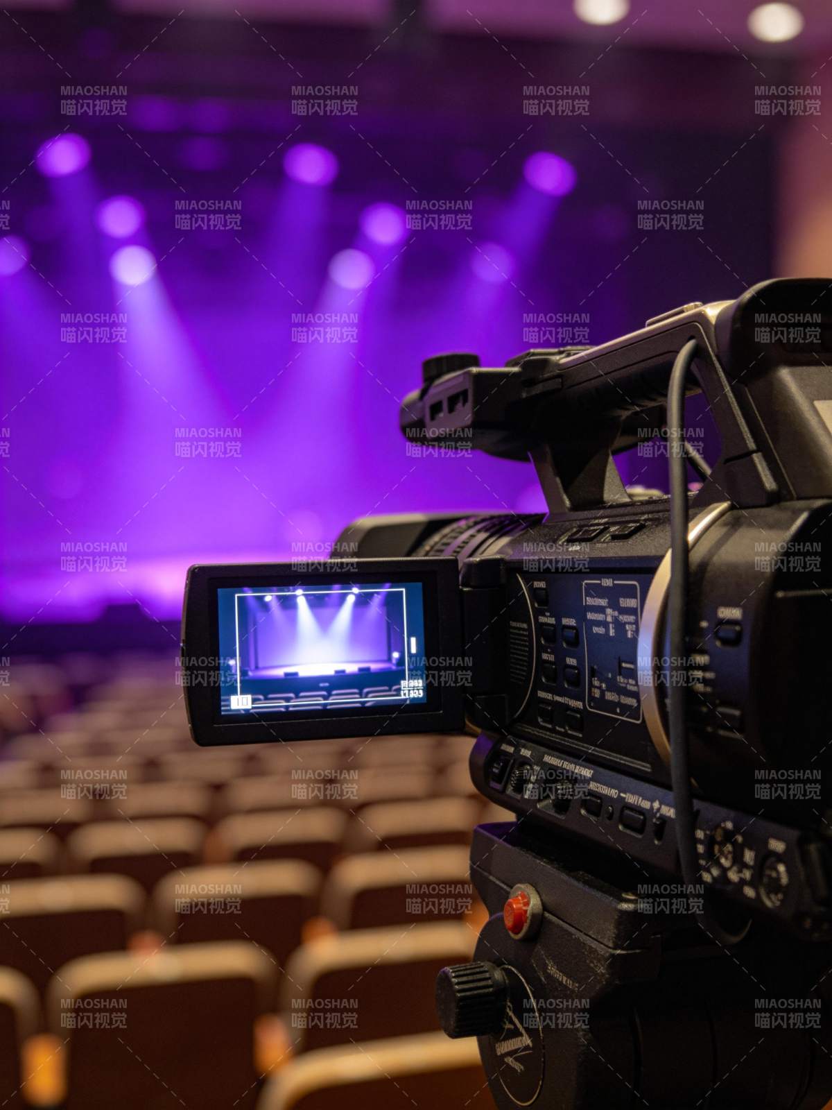 专业摄像机对准舞台灯光下的空剧场图片