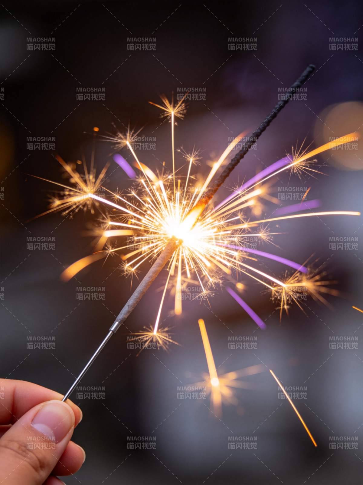 手持点燃的烟花棒绽放火花特写图片