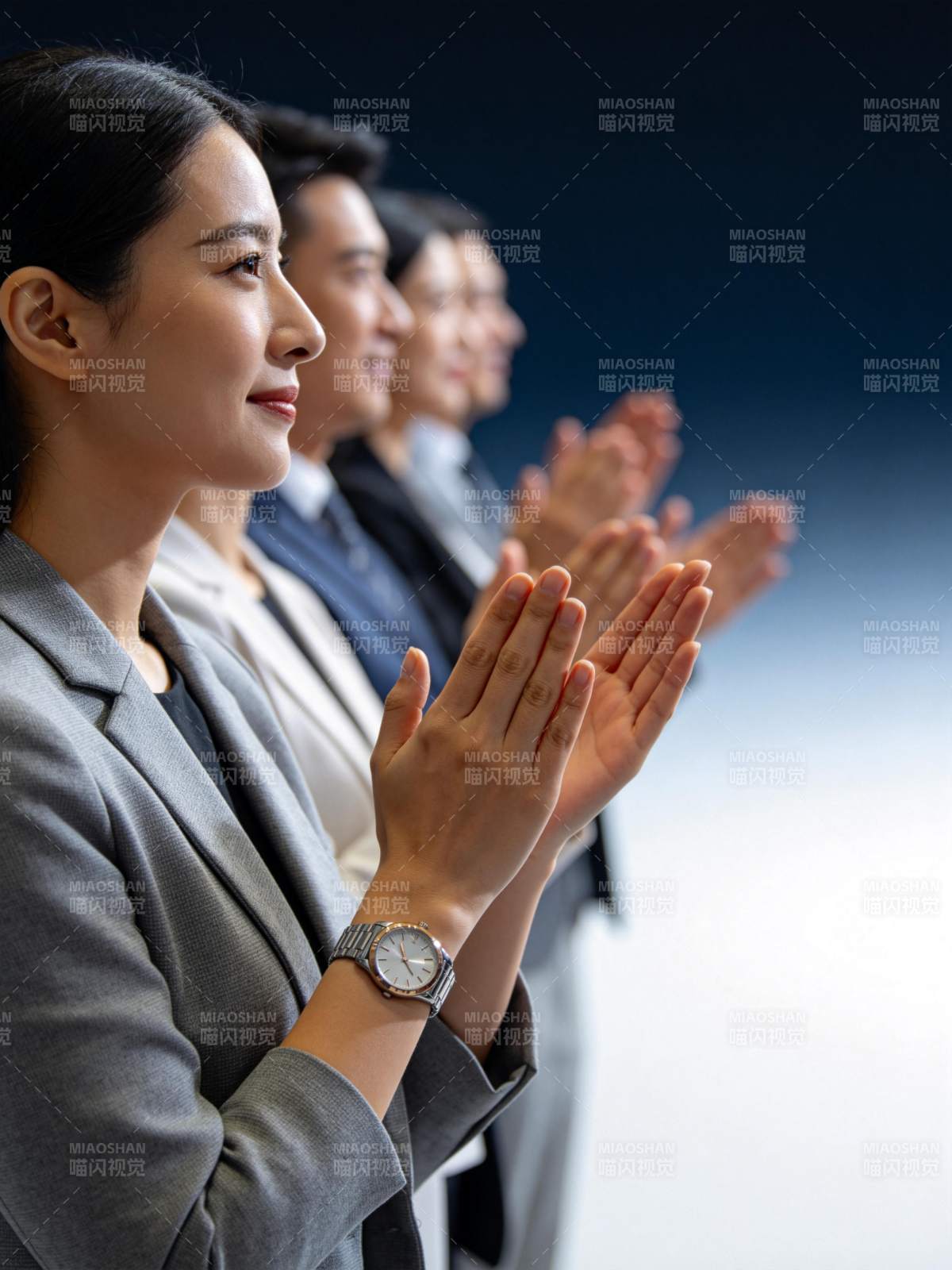 四位职场人士整齐鼓掌专注观看前方图片