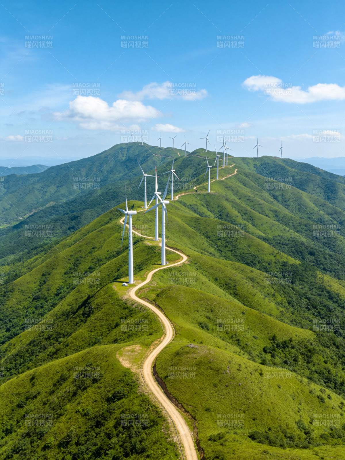青山之巅蜿蜒山路旁矗立多座风力发电机图片