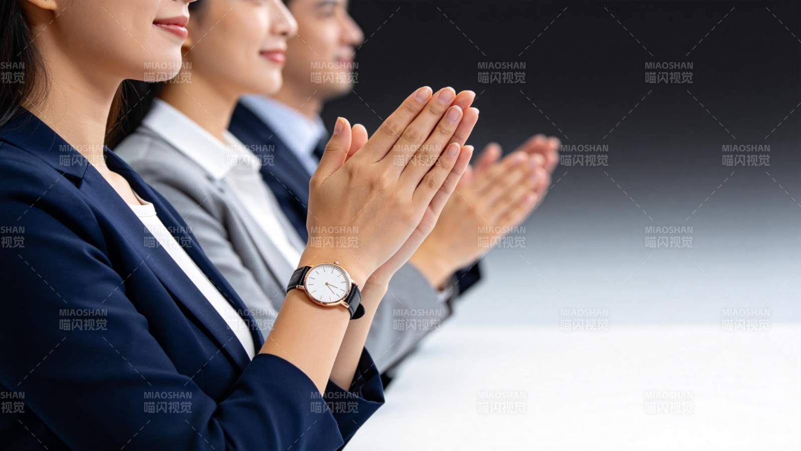 三位职场人士并排鼓掌致意场景图片