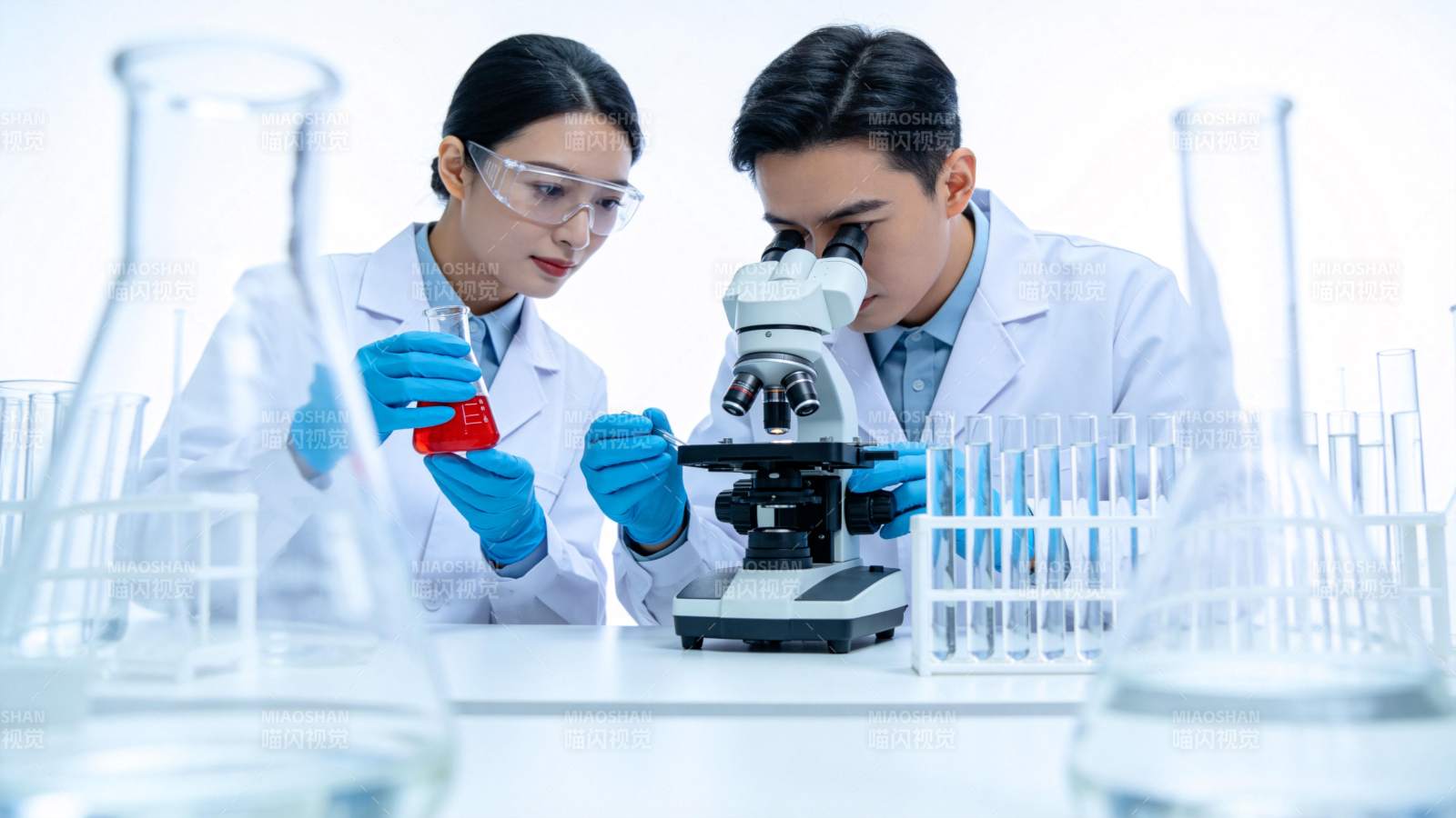 实验室中科研人员使用显微镜进行实验分析图片