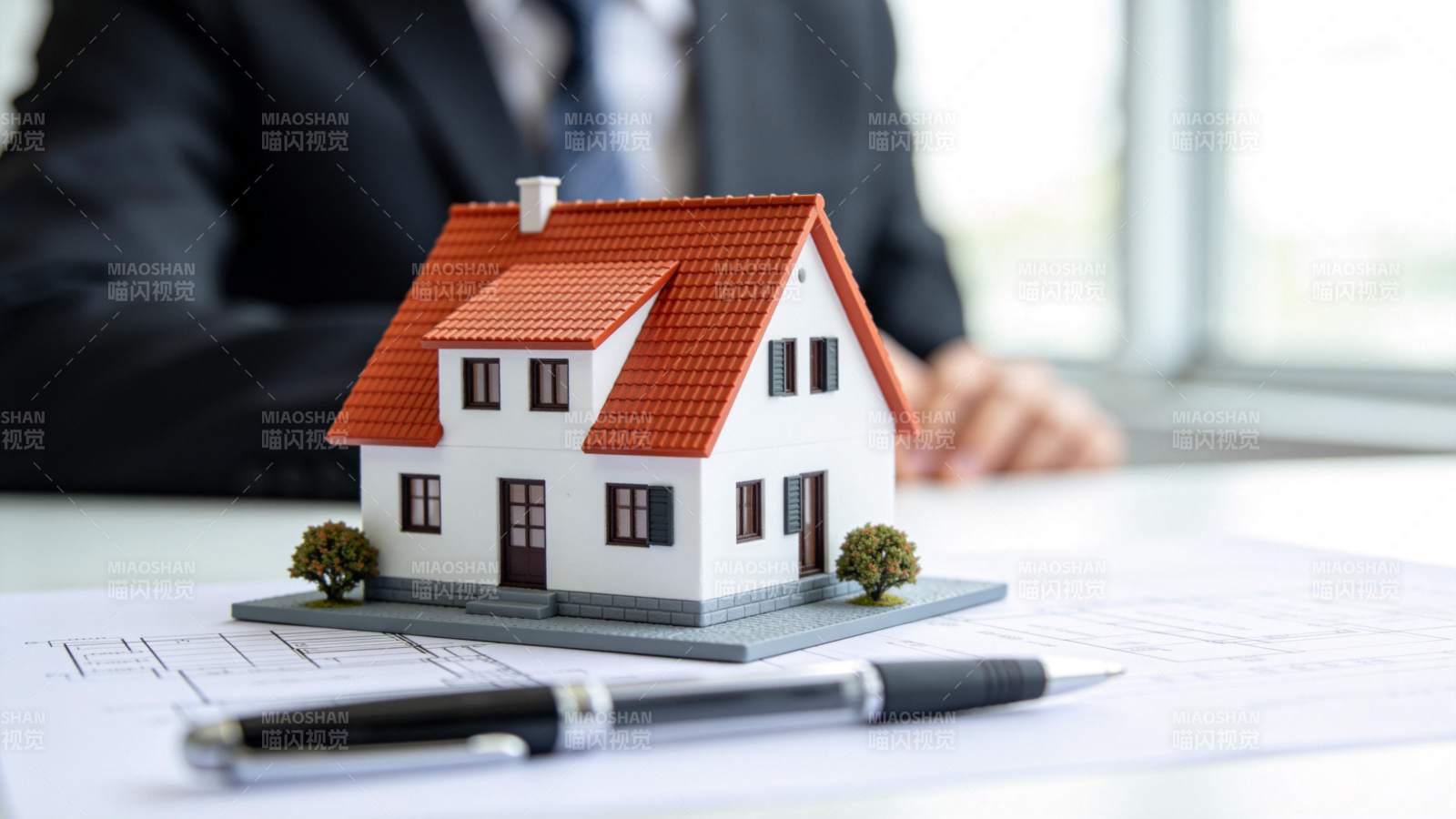 办公桌上房屋模型与建筑图纸及签字笔图片