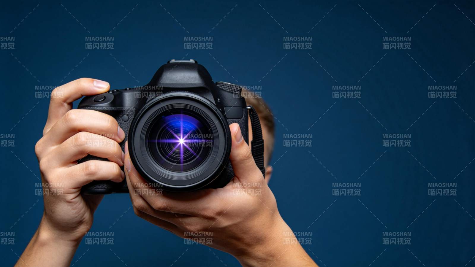 双手持单反相机对准镜头拍摄特写图片