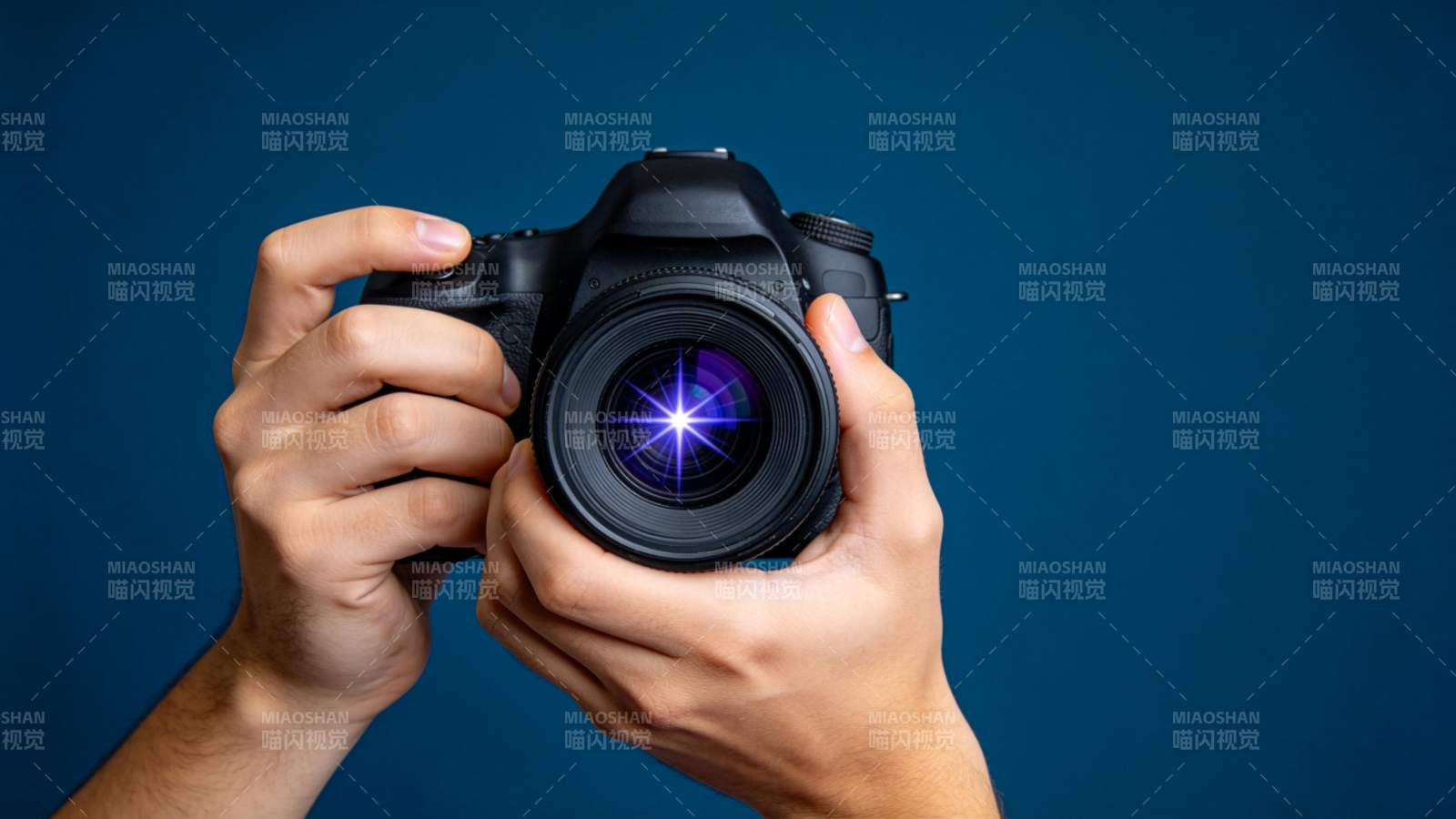 双手持单反相机对准镜头拍摄特写图片