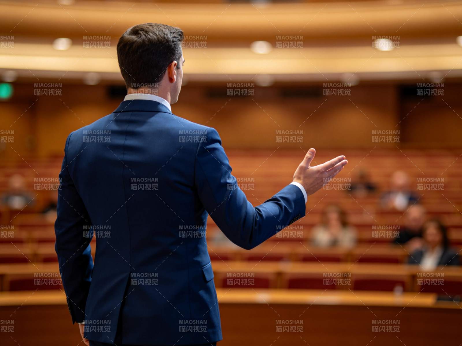 男士背对观众在讲台演讲手势示意图片