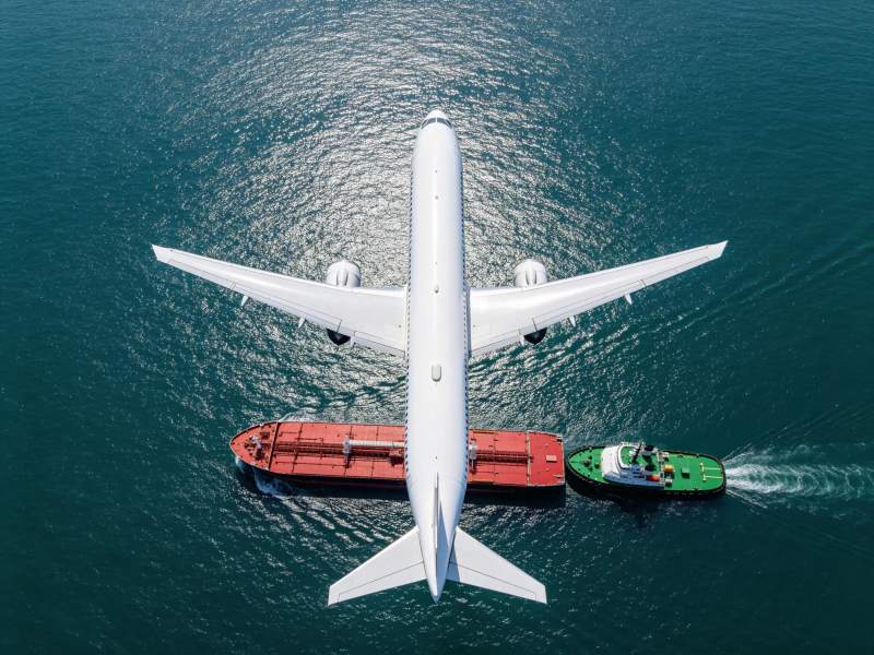 飞机货轮拖船同框海上运输场景图片