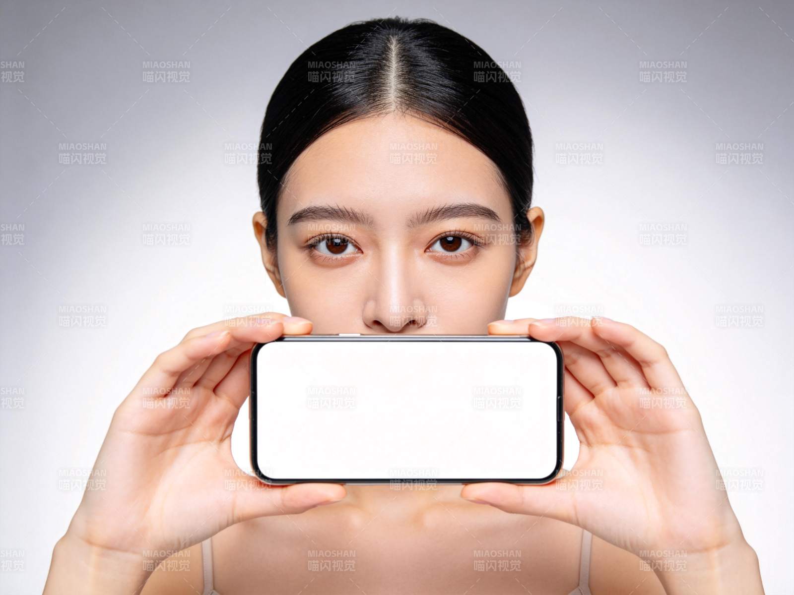 女性双手持空白手机遮挡口鼻部位图片