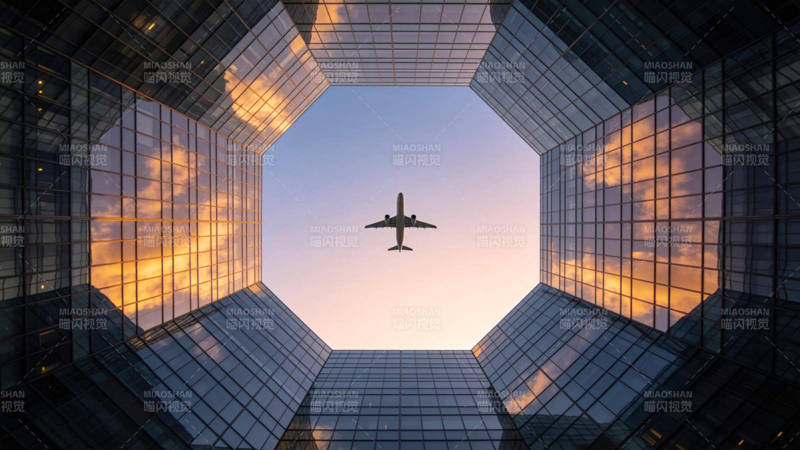 玻璃幕墙高楼间飞行的客机仰拍视角图片