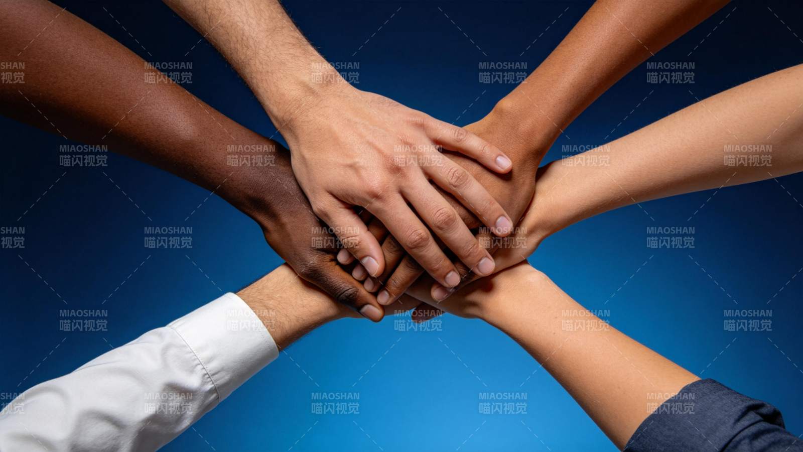 多只不同肤色手臂叠放象征团队合作图片