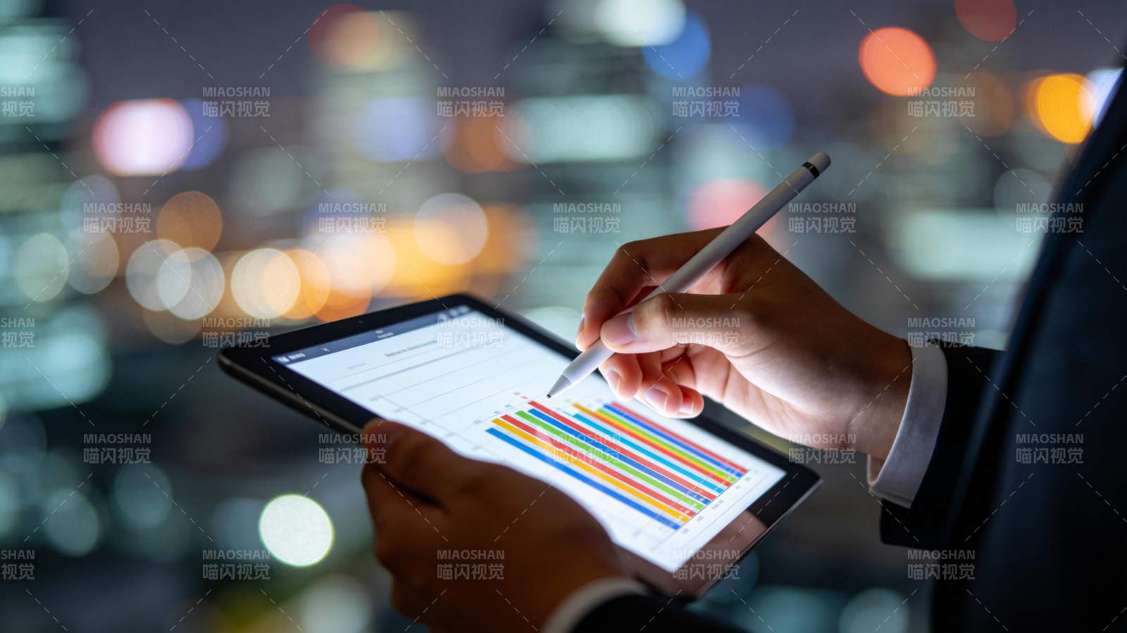 商务人士夜间使用平板分析彩色数据图表图片