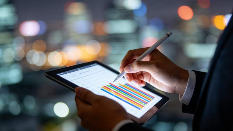 商务人士夜间使用平板分析彩色数据图表图片