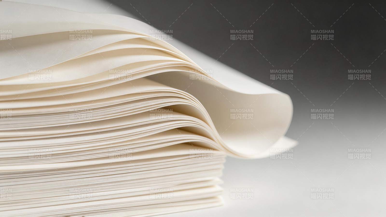 一叠米白色纸张边缘自然卷曲特写图片