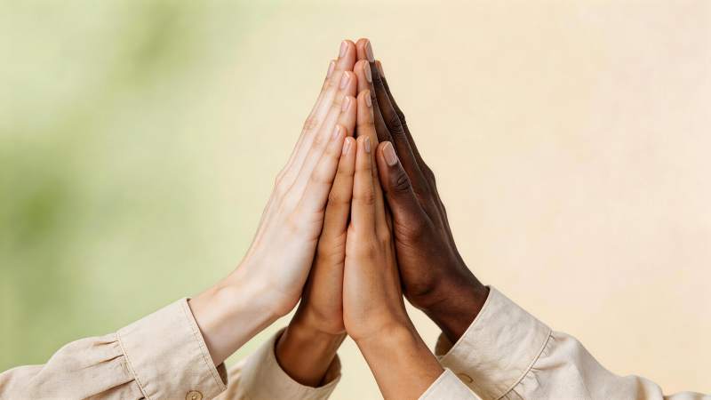 四只不同肤色手掌合十叠放特写图片