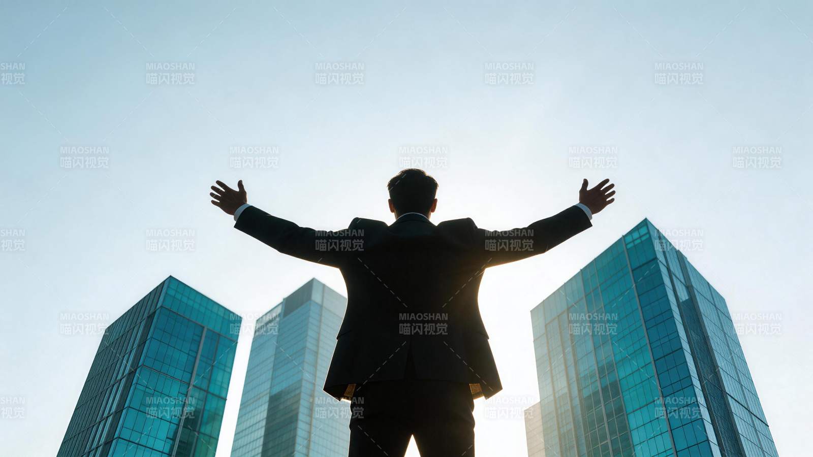 西装男子背对镜头张开双臂面对高楼群图片