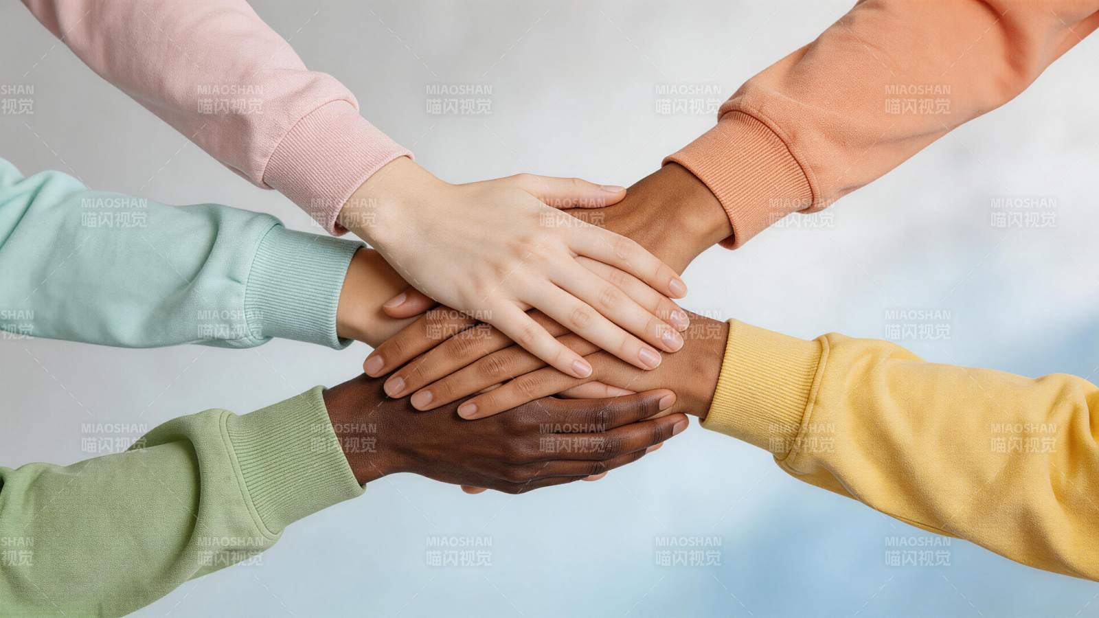 五只不同肤色的手叠放在一起象征团结合作图片