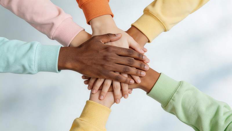 多人叠手象征团结协作的特写画面图片