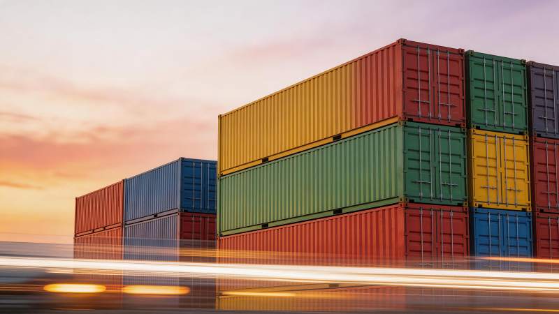 彩色集装箱堆叠在黄昏公路旁图片