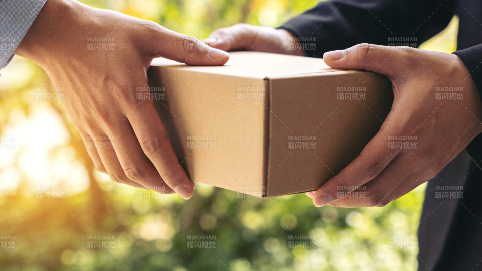 两人交接棕色纸箱包裹特写图片