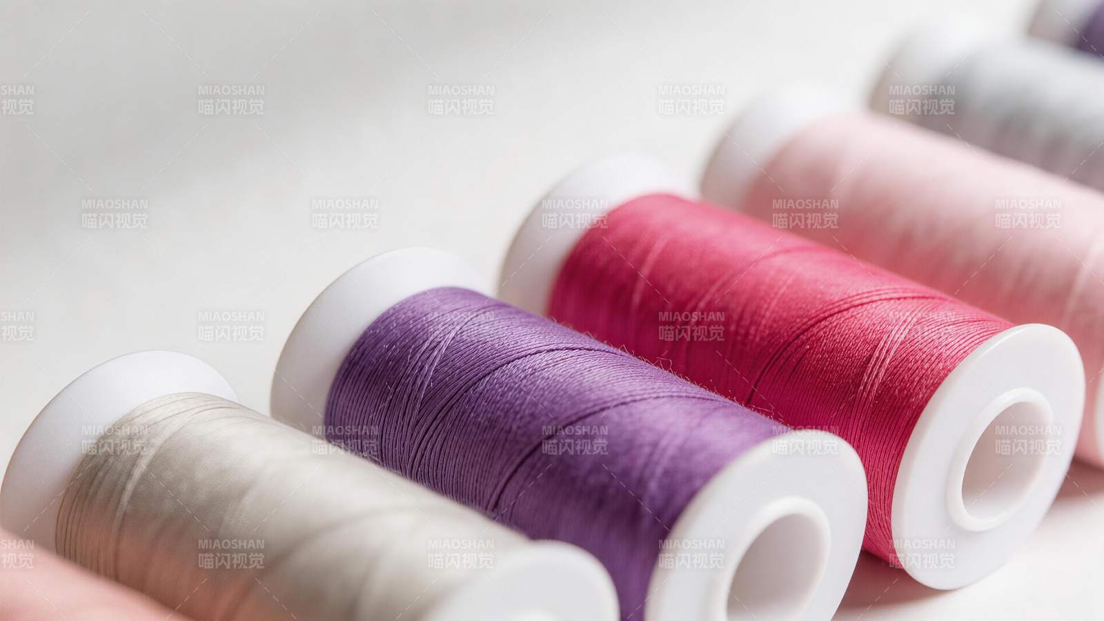 多色缝纫线卷整齐排列特写图片