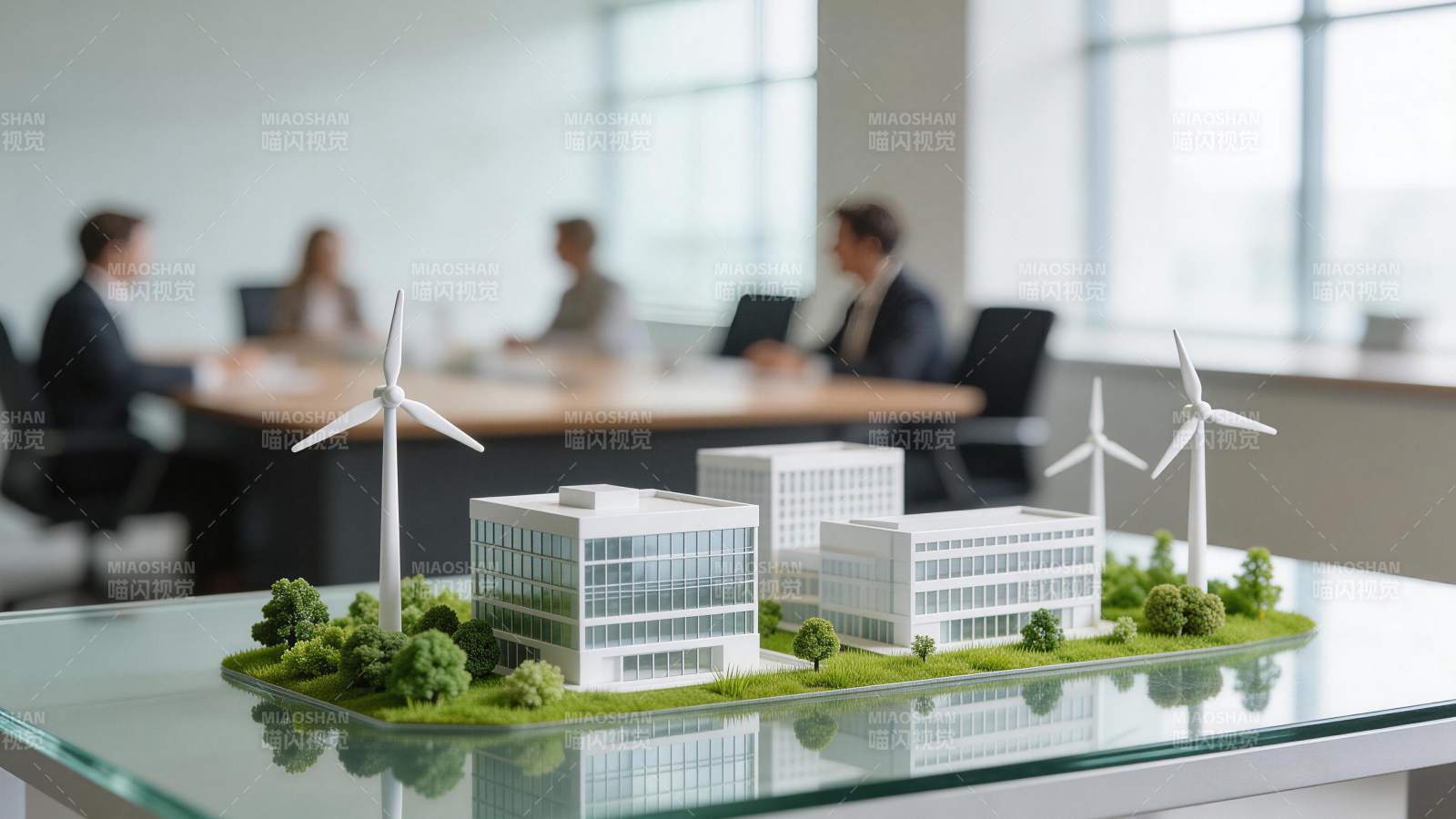 办公桌上绿色能源建筑模型与会议场景图片