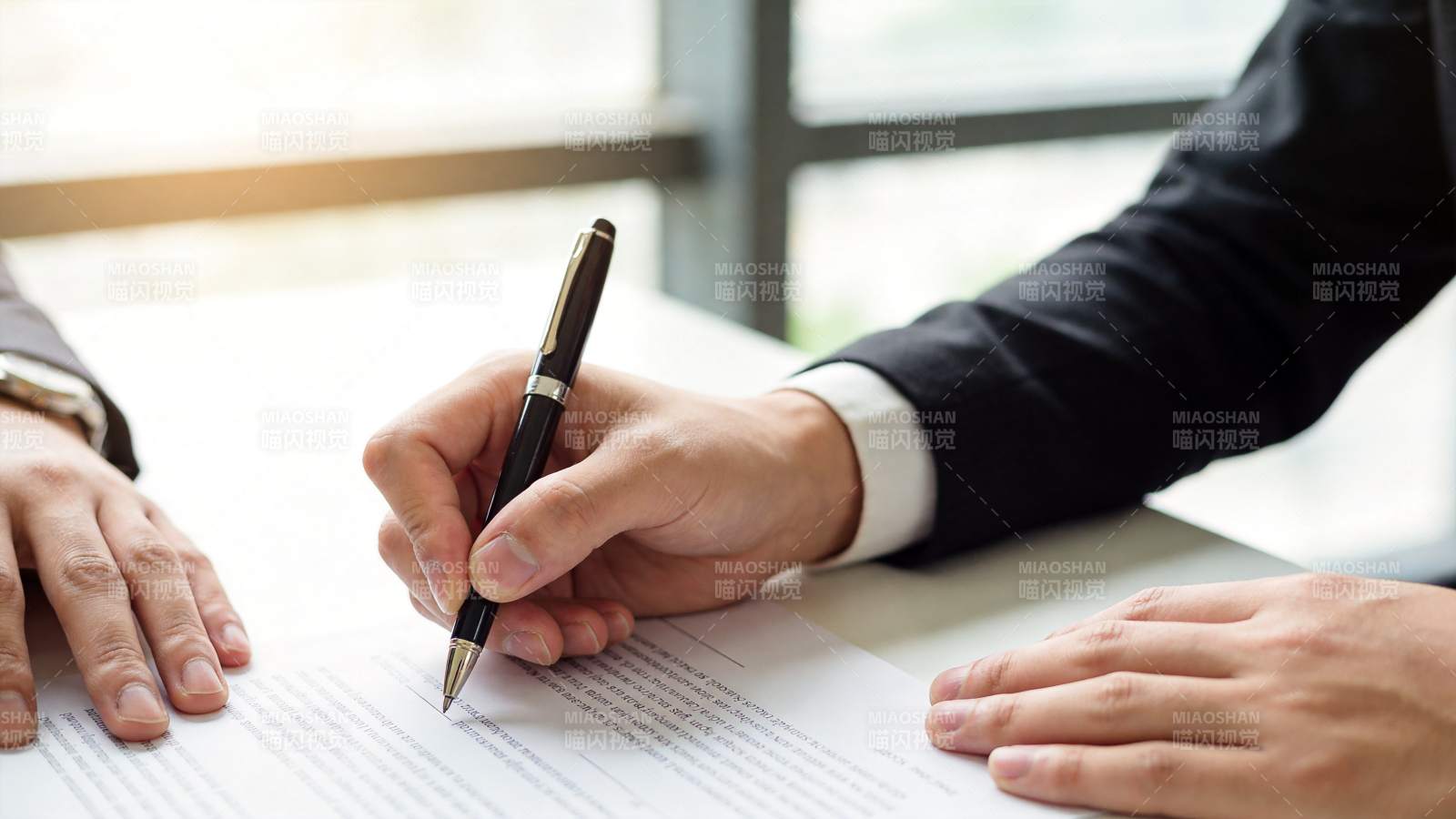 商务人士手持钢笔签署文件特写图片