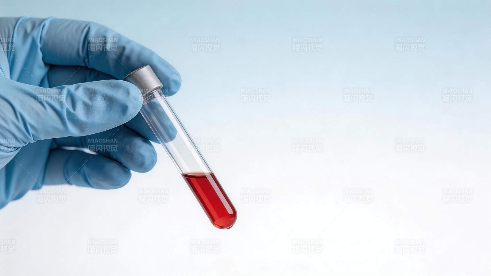 戴蓝色手套手持装有红色液体的试管图片