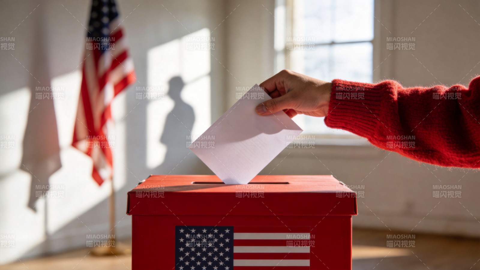 红色投票箱前投递选票的手部特写图片