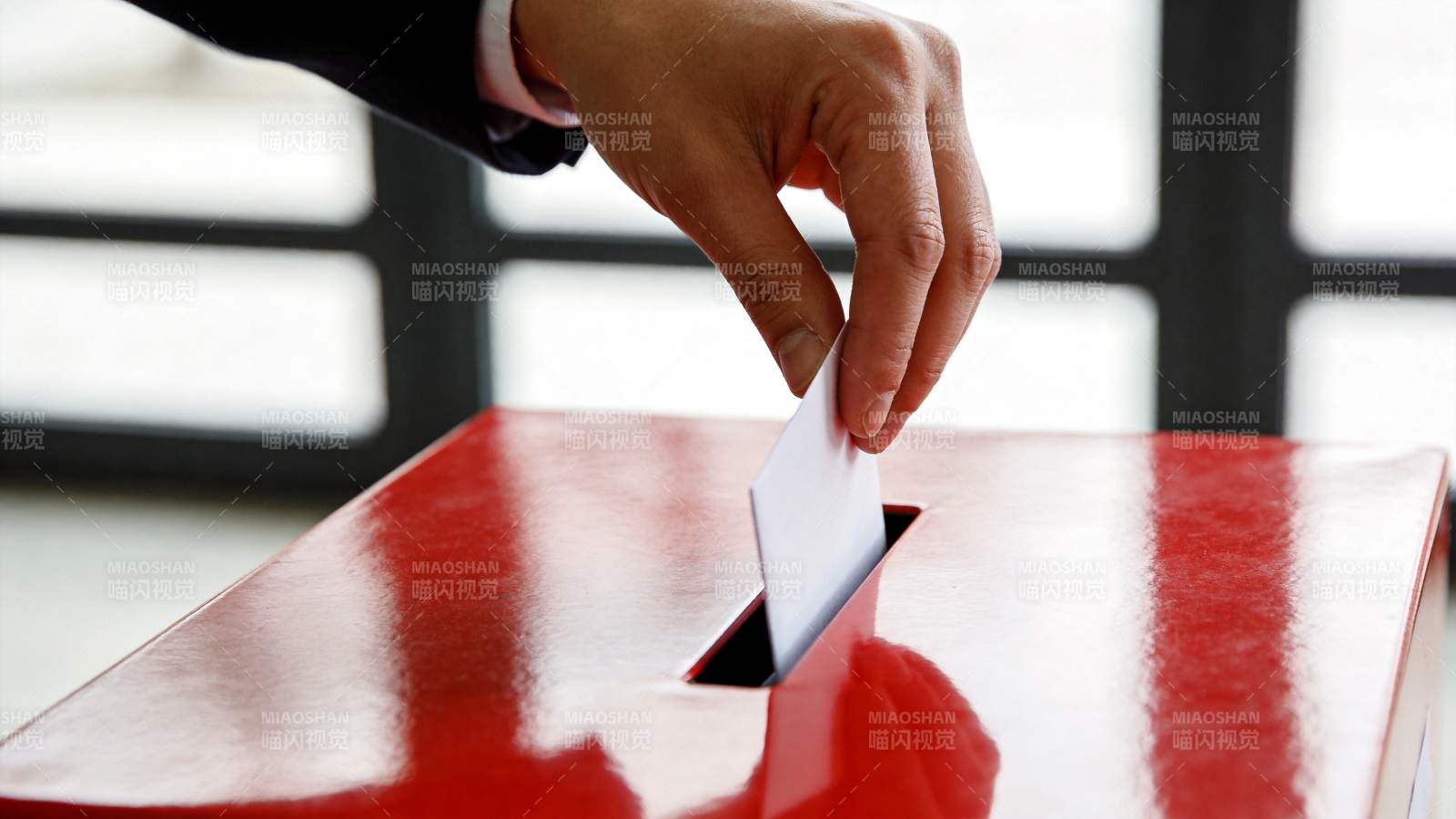 手将选票投入红色投票箱投递口图片