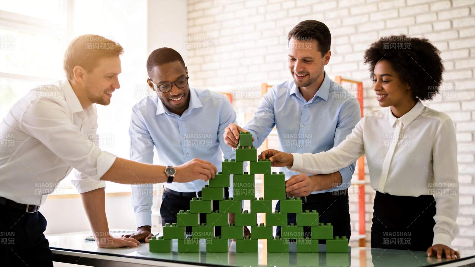四人协作搭建绿色积木金字塔模型图片