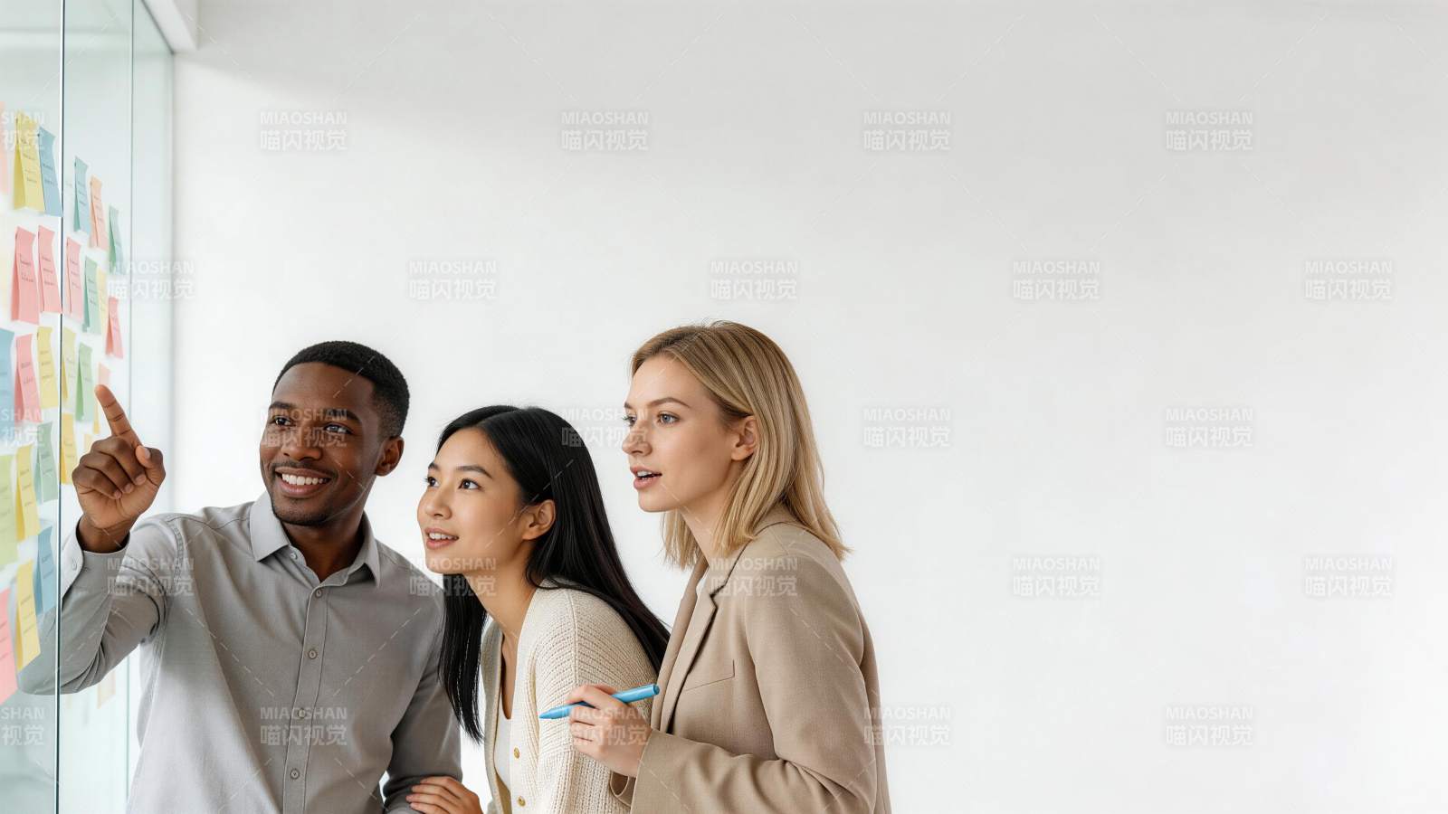 三位职场人士在玻璃墙前讨论便签内容图片