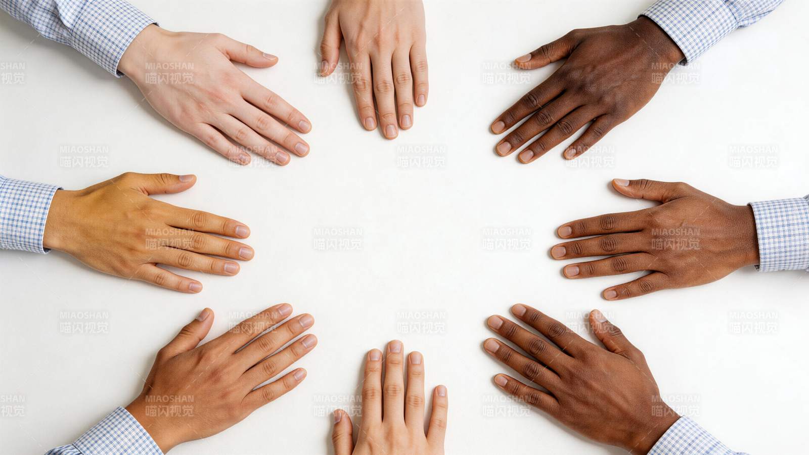 多只不同肤色手掌围成圆圈置于白桌面上图片