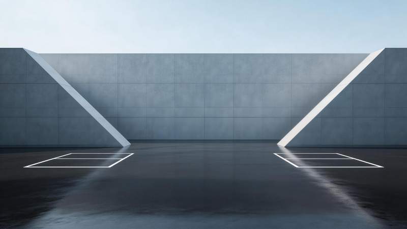 灰色混凝土墙前两个白色停车框与斜面结构图片