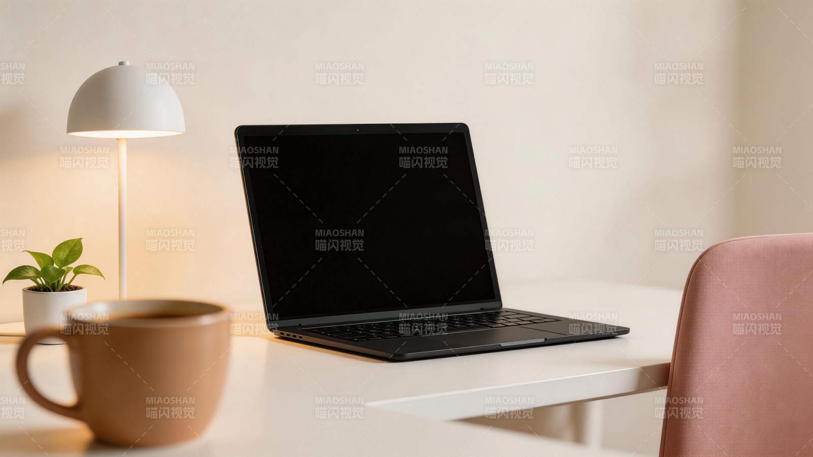 白色桌面上摆放笔记本电脑与台灯绿植咖啡杯图片