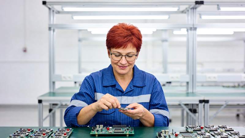 红发女工在车间组装电子电路板图片