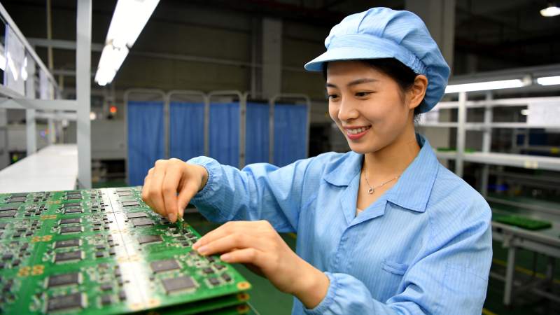 女工人在车间组装绿色电路板图片
