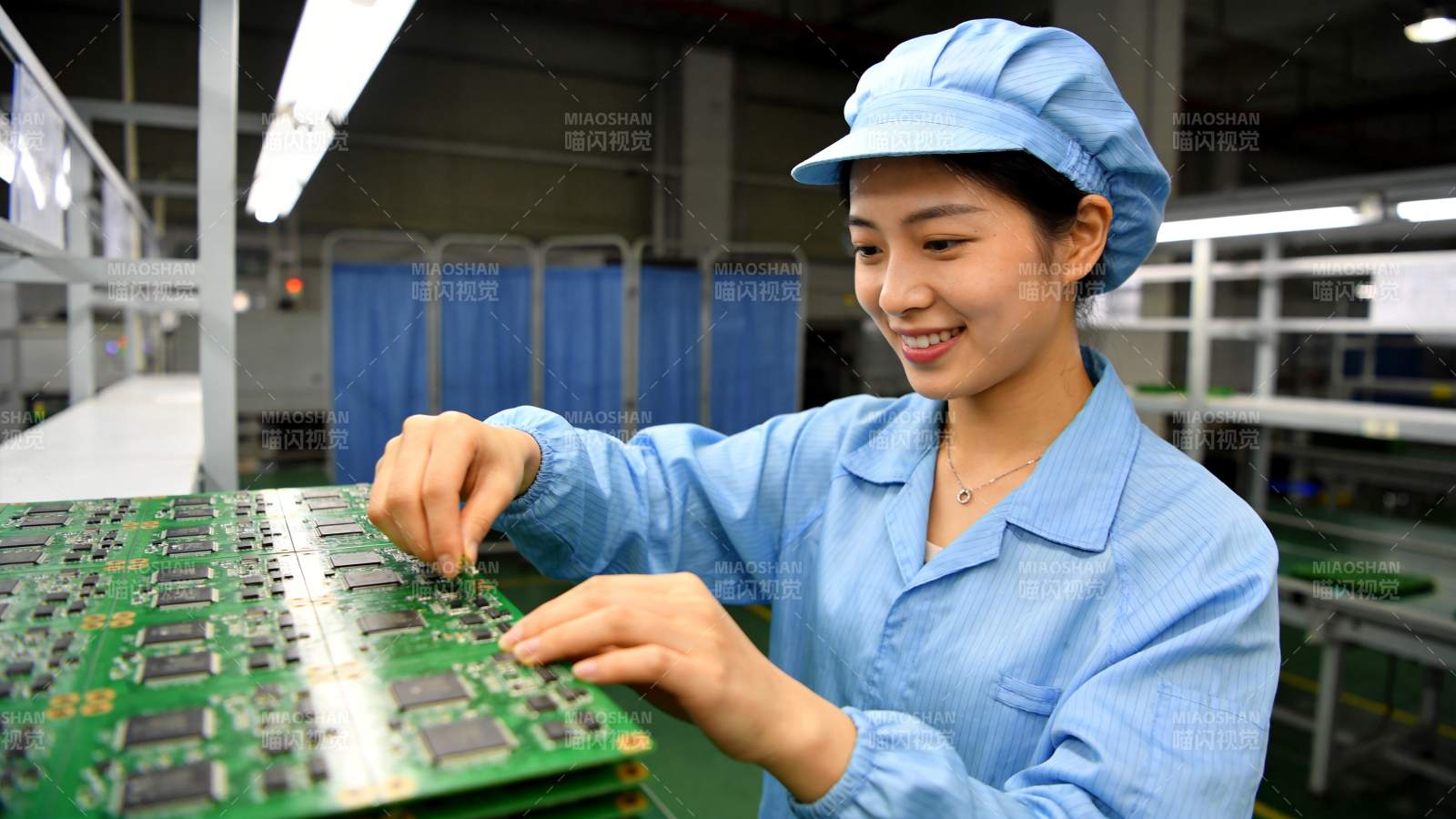 女工人在车间组装绿色电路板图片