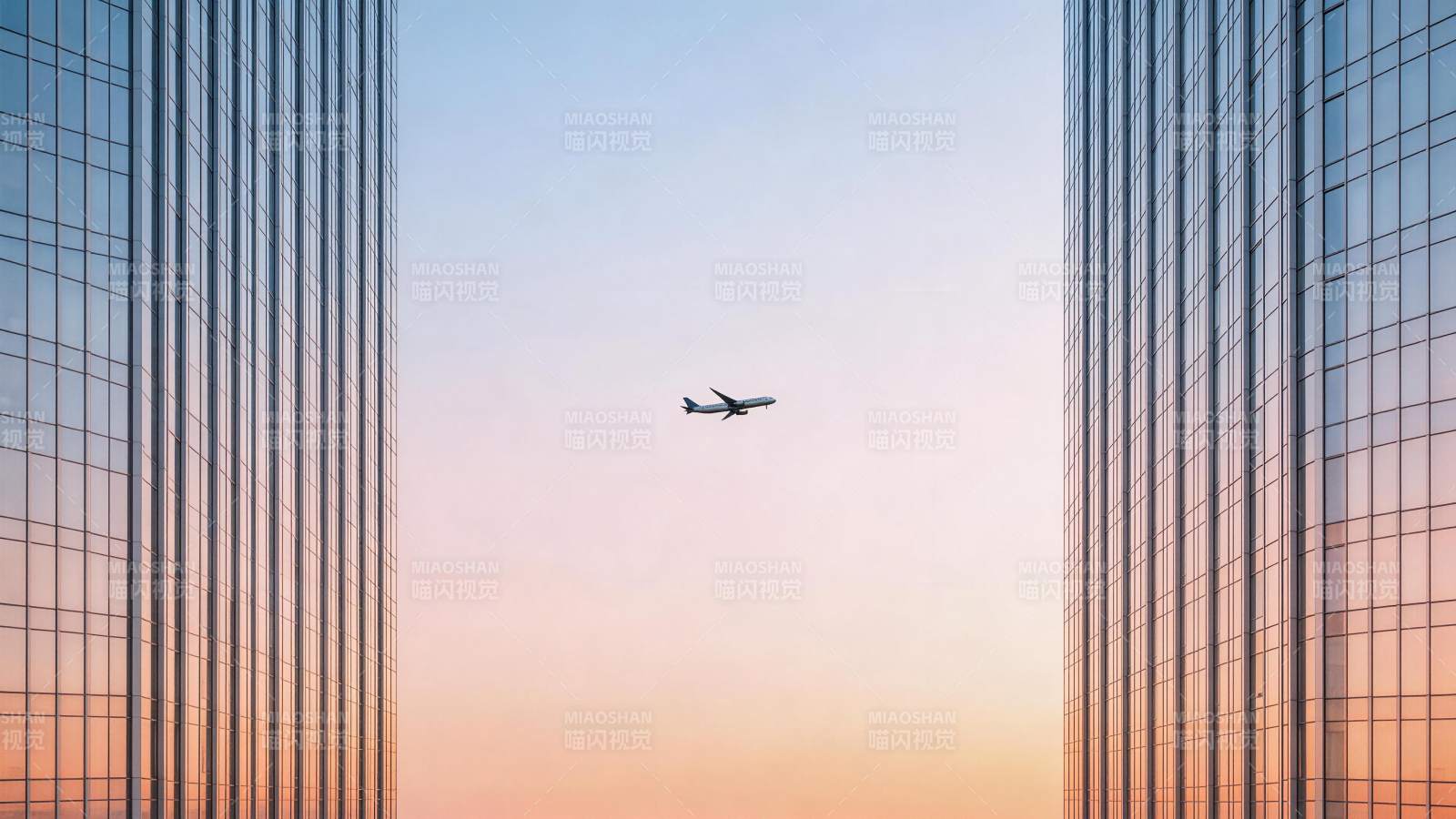 高楼之间飞行的客机与渐变天空图片