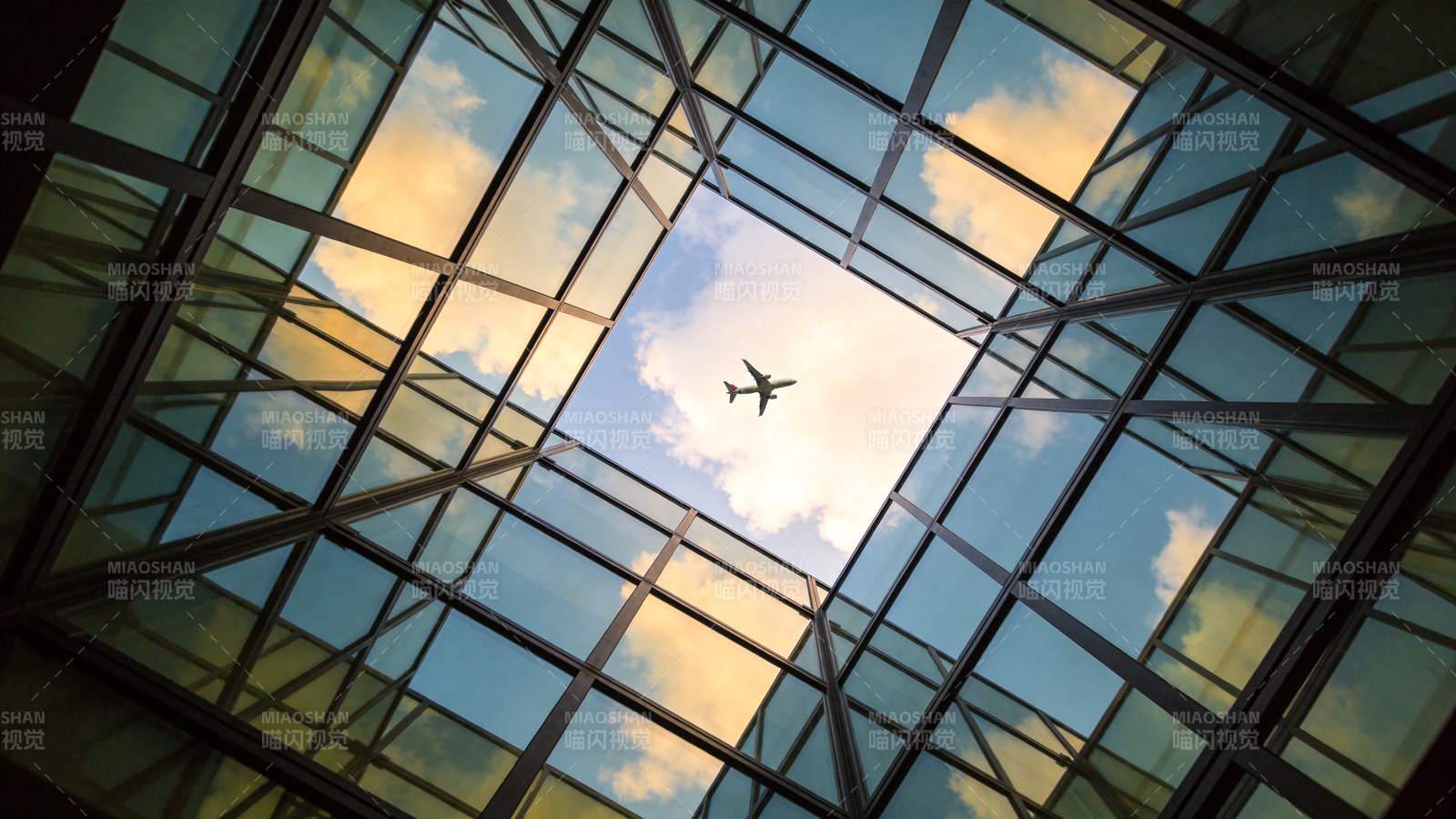 玻璃天窗下飞行的客机与云彩天空图片