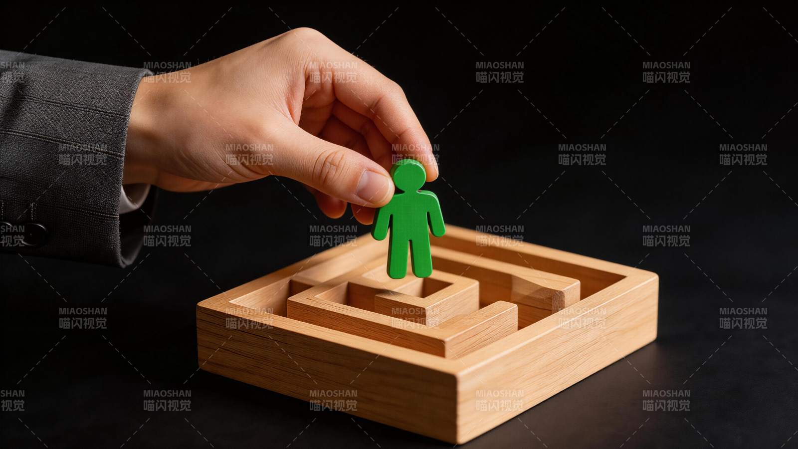 手握绿色人形棋子置于木质迷宫上方图片