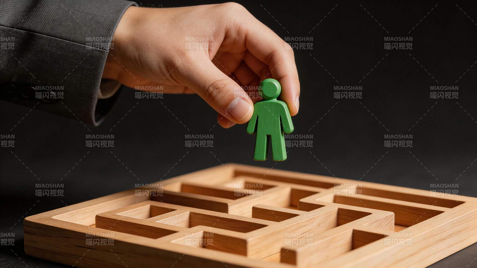 手握绿色人偶置于木质迷宫上方图片