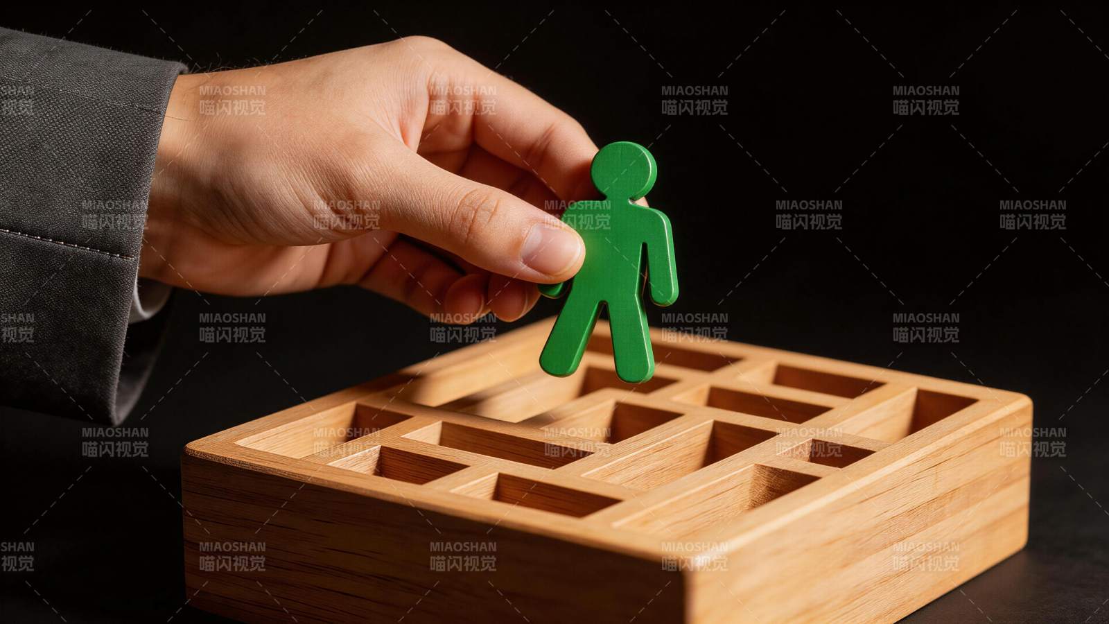手握绿色人形棋子置于木质迷宫上方图片